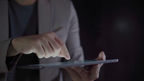 4K-Video-close-up-man-hand-in-suit-using-tablet-with-black-background.