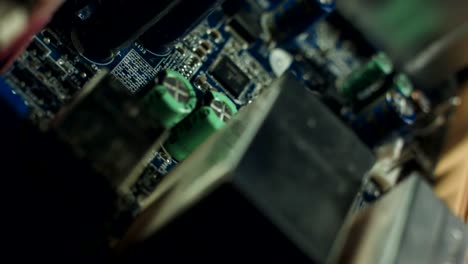 Closeup-on-electronic-board-in-hardware-repair-shop,-blurred-and-toned-image.-Shallow-DOF,-focus-on-the-middle-left-field