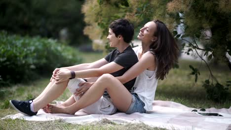 Two-pretty-lesbians-sitting-and-talking-on-glass