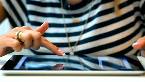 Close-up-of-a-young-girl-using-her-tablet-tablet-computer-at-the-table-in-the-room