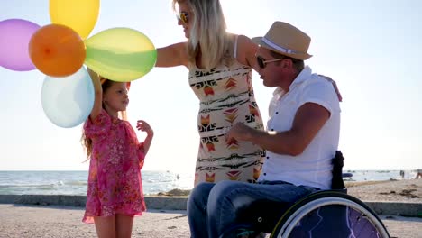 disabled-Man-In-wheelchair-with-child-consider-belly-of-pregnant-mom,-invalid-with-wife-and-daughter