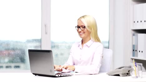 woman-secretary-or-student-in-eyeglasses-with-laptop-typing-in-office