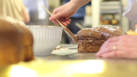 Pastry-Chef-Hände-glasiert-Osterkuchen-süßes-Brot-mit-Schokolade,-Nahaufnahme-auf-der-Arbeitsplatte-in-der-Konditorei