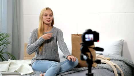 Cheerful-female-blogger-showing-her-sweater