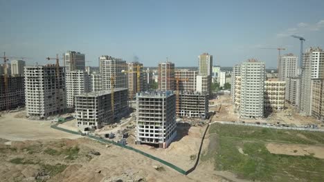 Vista-aérea.-Construcción-de-un-moderno-barrio-con-infraestructura-desarrollada-y-apartamentos-residenciales.-Un-sitio-de-construcción-con-grúas-y-edificios-altos.-Venta-y-alquiler-de-bienes-inmuebles