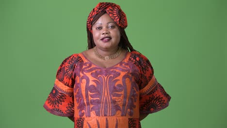 Overweight-beautiful-African-woman-wearing-traditional-clothing-against-green-background