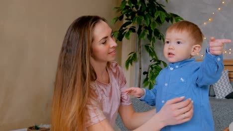 Glückliche-junge-Mutter-und-ihr-Baby-Sohn-spielen-togerher