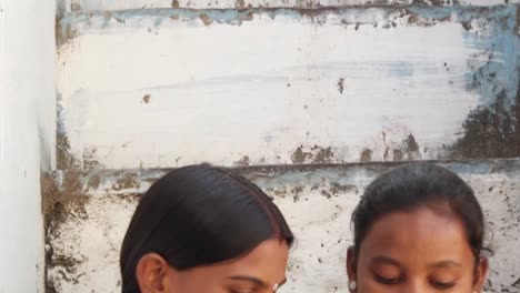 Tilt-down-Extreme-closeup-de-las-mujeres-indias-un-dispositivo-móvil-inteligente-y-escuchando-música-golpeando-los-dedos-mirando-a-cámara-y-a-su-dispositivo-móvil-y-tener-un-buen-tiempo-juntos-compartiendo