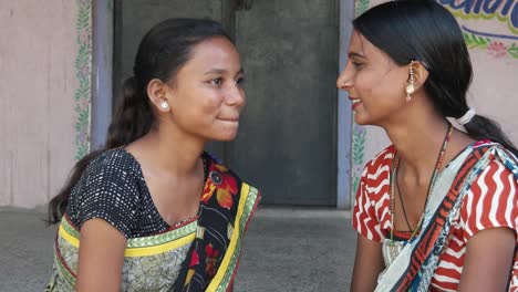 Two-girlfriends-share-whisper-news-laugh-smile-gossip-tell-secrets-stories-rumor-look-around-two-shot-static-close-up-rural-Indian-traditional-costume-dress-makeup-pretty-beautiful-home-love-share