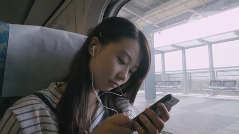 Woman-using-smartphone-on-train