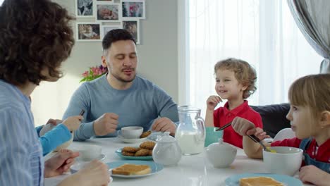 Familia-con-tres-niños-desayunando