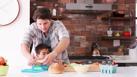 Padre-e-hijo-haciendo-sándwiches-para-el-almuerzo-en-la-cocina