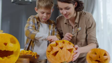 Joyful-Boy-Making-Jack-o-Lantern-with-Mom