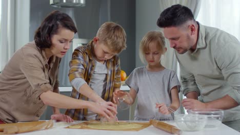 Kinder-schneiden-Plätzchenteig-mit-Hilfe-der-Eltern