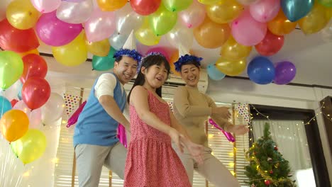 Happy-young-Asian-family-dancing-together-in-party-event-at-home.-Happy-family-celebrating-New-Year's-Eve.