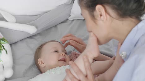 Joven-mujer-y-bebé-relajante-en-cama