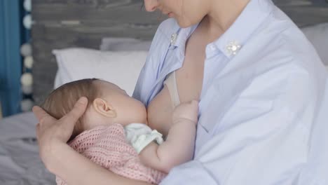 Unrecognizable-mother-breastfeeding-her-baby-on-bed