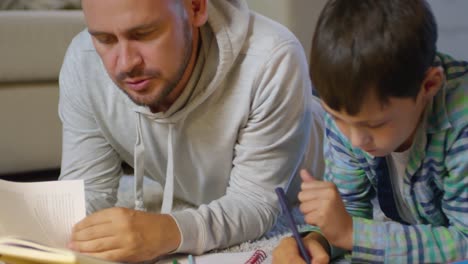 Dad-and-Son-Doing-Homework-Together-on-the-Floor