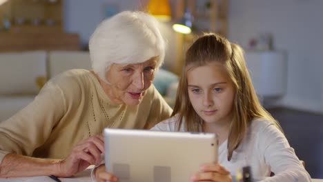 Grandma-Using-Digital-Tablet-with-Young-Granddaughter