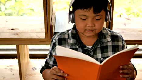 Süße-asiatische-Kinder-ein-Buch-lesen-und-hören-Sie-Musik-zu-Hause.-Bildungskonzept