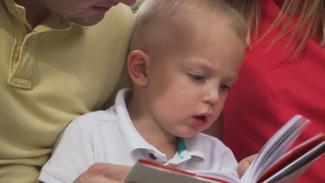 Ein-kleiner-Junge-mit-seinen-Eltern-Riten-ein-Buch.-Close-up