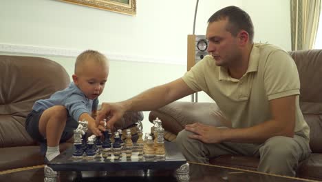 Young-dad-playing-chess-with-his-little-son