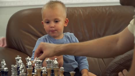 Father-gives-chess-lessons-to-his-little-son