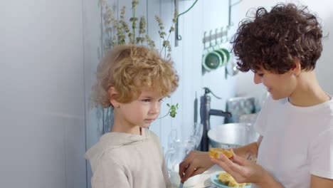 Madre-haciendo-Sandwich-para-niño-juguetón