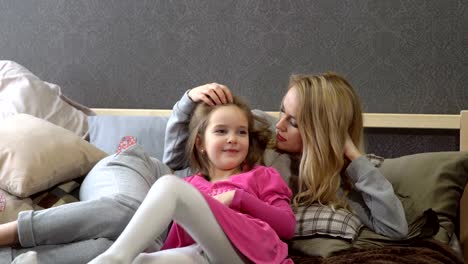 Maternidad.-Madre-e-hija-son-acostado-en-la-cama.