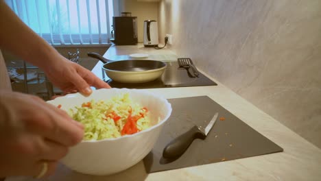 Father-in-a-striped-shirt-is-cooking-fresh-organic-vegetable-salad,-healthy-eating-for-children