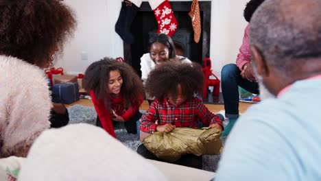 Eröffnung-der-Sohn-Geschenk-als-Multi-Generationen-Familie-Weihnachten-feiern-zu-Hause-zusammen