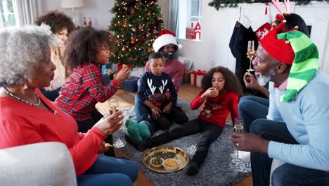 Multi-generación-familia-sombreros-de-fiesta-que-celebran-la-Navidad-en-casa-junto