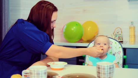 Mutter-füttert-das-Baby-in-der-Küche