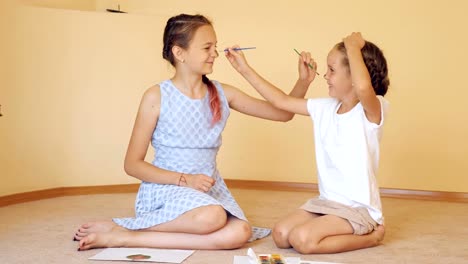 Felizes-hermanas-jugando-con-pinturas,-pinceles