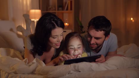 happy-family-with-tablet-pc-in-bed-at-home