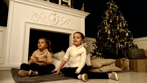 Two-little-girls-pose-during-Christmas-photo-session.-Studio-shooting-before-the-holidays