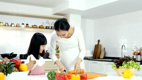 Little-girl-try-to-cooking-by-herself-at-kitchen.-Mother-teaching-her-daughter-to-cooking.-People-with-lifestyle-and-healthy-concept.