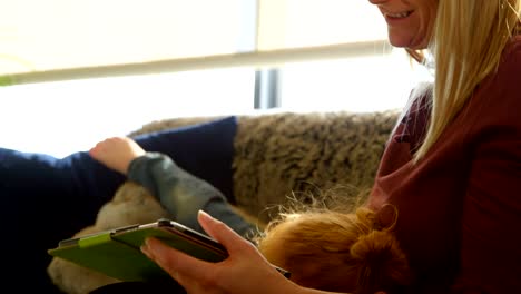 Madre-e-hijo-con-tableta-digital-en-sala-de-estar-en-casa-4k