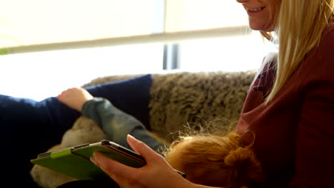 Mother-and-son-using-digital-tablet-in-living-room-at-home-4k