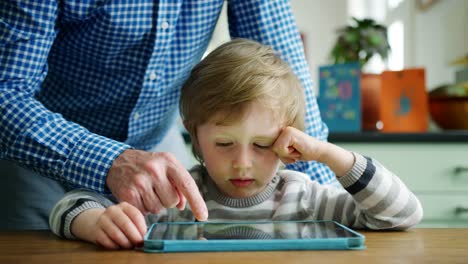 Father-Showing-Son-How-To-Use-Digital-Tablet