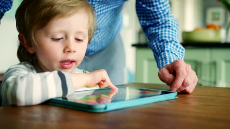 Father-Showing-Son-How-To-Use-Digital-Tablet