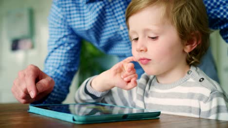 Father-Showing-Son-How-To-Use-Digital-Tablet