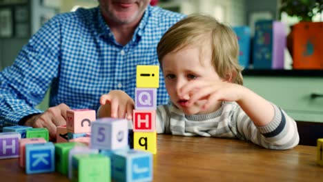 Vater-und-Sohn-spielen-mit-Holzklötzen