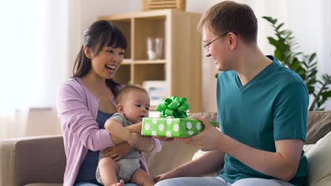 mother-with-baby-giving-birthday-present-to-father