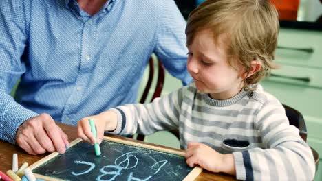 Vater-Lehre-Sohn-schreiben-mit-Kreide-und-Tafel