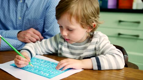 Father-Teaching-Son-How-To-Write-Using-Stencil