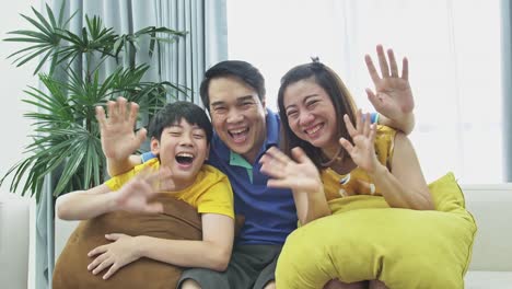 Slow-motion-of-asian-family-father-mother-and-son-on-couch,-Looking-at-camera--with-smile-face.