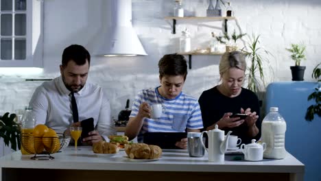 Familia-sentado-en-la-mesa-de-la-cocina