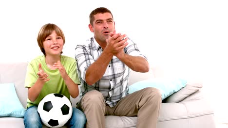 En-cámara-lenta-feliz-Padre-e-hijo-mirando-de-fútbol