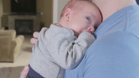 Vater-holding-Neugeborenes-Kind-im-Wohnzimmer